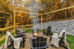 a fire pit in a backyard with chairs and a fireplace at Dream Chaser - Adventure Gateway in Gatlinburg