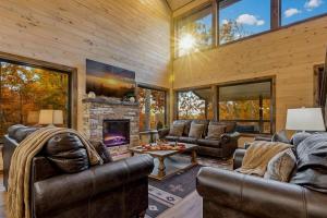 a living room with leather furniture and a fireplace at Dream Chaser - Adventure Gateway in Gatlinburg