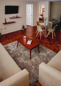 a living room with a coffee table and chairs at Business and Family Hermoso departamento en Ambato in Ambato