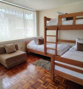 a room with two bunk beds and a window at Business and Family Hermoso departamento en Ambato in Ambato +10 photos