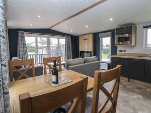 a kitchen and a dining room with a table and chairs at Meadows Park 3 in Hull +14 photos