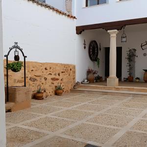 a courtyard of a building with potted plants and a wall at La Fragua de Domingo in Villanueva de los Infantes
