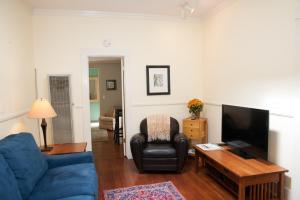 een woonkamer met een blauwe bank en een tv bij Chapala Gardens Historic West Beach 1BR - Unit 2 in Santa Barbara