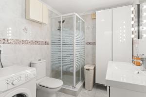 Un baño blanco con inodoro y ducha. en Apartamento Butiplaya, en La Cala de Mijas