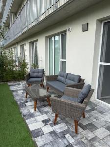a patio with two couches and a table and chairs at Apartmán Lottner in Kysucké Nové Mesto
