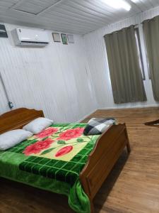 Un dormitorio con una cama con una manta verde. en Recanto do Zeca, en Bento Gonçalves 5 fotos más