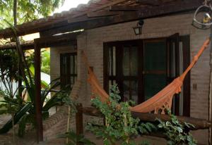 a house with a hammock in front of it at Pousada Praia da Pipa in Pipa