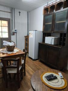 a kitchen with a table and a white refrigerator at Recanto do Zeca in Bento Gonçalves