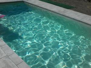 een zwembad met blauw water in een achtertuin bij Casa Guaitoli in Bagni di Petriolo