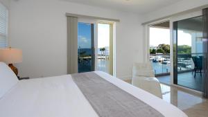 a white bedroom with a large bed and a balcony at 131 Mariners Club in Key Largo +64 photos