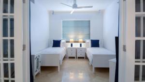 a white bedroom with two beds and a window at 131 Mariners Club in Key Largo +37 photos
