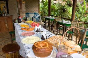 a long table with food and bread on it at Pousada Praia da Pipa in Pipa