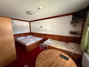 a small room with two beds and a table at Pension Kohler in Deštné v Orlických horách +31 photos