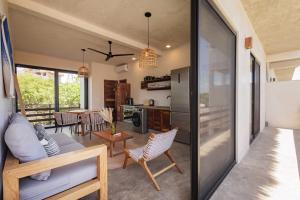 Santa María ColotepecにあるCozy 2BR Apto Terrace, Pool & AC Steps from Beachのキッチン、リビングルーム(ソファ、椅子付)