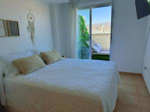 a bedroom with a bed and a large window at Ático junto al Teatro AUDITORIO de Roquetas de Mar in Roquetas de Mar +73 photos
