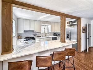 a kitchen with white cabinets and a counter with chairs at Higher Ground in Highlands