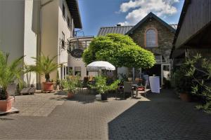 a courtyard with potted plants in front of a building at Weingut Koch in Neumagen-Dhron