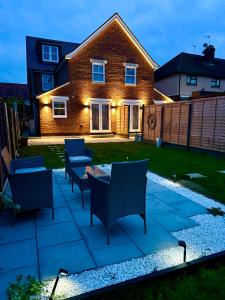 a patio with chairs and a table in front of a house at DSK Residencia in Maidstone +73 photos