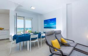 a dining room with a blue table and chairs at Nice Home In Privlaka in Glavan