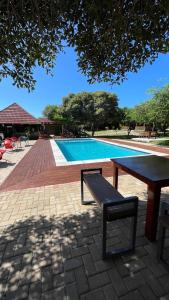 - une table de pique-nique et un banc à côté de la piscine dans l'établissement Cycad Beach Resort- Chalets, à Praia de Macaneta