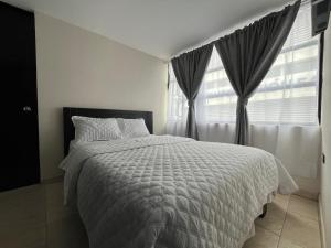 a bedroom with a large bed and a window at Hotel Monaco in Ipiales