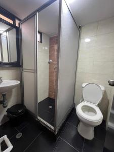 a bathroom with a shower and a toilet and a sink at Hotel Monaco in Ipiales