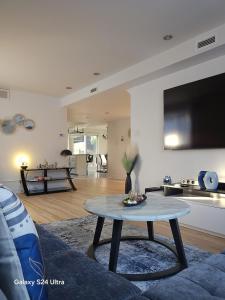 a living room with a table and a tv at Appartement, Jacuzzi, Spa et terasse in Longueuil
