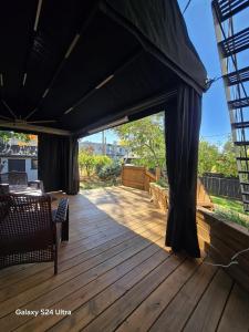 a wooden deck with a black tent on it at Appartement, Jacuzzi, Spa et terasse in Longueuil