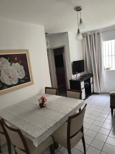 a dining room with a table and chairs and a living room at Ap confortável e Aconchegante in Petrolina