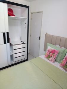 a bedroom with a mirror and a bed with pink flowers at Ap confortável e Aconchegante in Petrolina