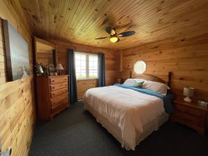 ein Schlafzimmer mit einem Bett in einer Blockhütte in der Unterkunft Stanhope Cottages in Stanhope