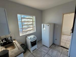 een keuken met een koelkast, een wastafel en een raam bij Casa com 2 quartos no Aero Rancho in Campo Grande