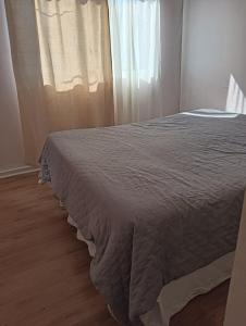 a bed in a room with a window at Casa Acquarella in Viña del Mar