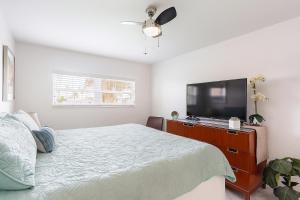 a bedroom with a bed and a flat screen tv at Oasis Waterfront Treasure Island Apartment with Patio Dock and Johns Pass in St Pete Beach