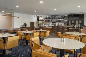 a restaurant with tables and chairs and a kitchen at Courtyard Casper in Casper