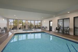 a large swimming pool with tables and chairs in a building at Courtyard Casper in Casper