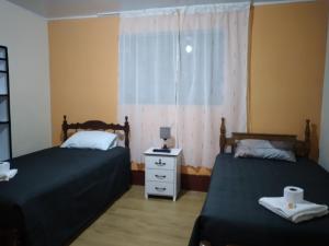 a bedroom with two beds and a window at Casa Hospedaje in Ayacucho