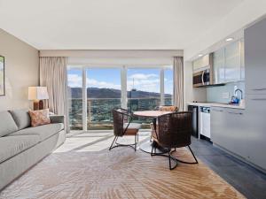a living room with a couch and a table with chairs at Ala Moana Honolulu by Mantra in Honolulu