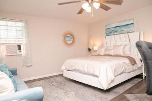a white bedroom with a bed and a ceiling fan at Serene Studio Retreat in Jacksonville