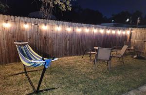 a fence with a table and chairs and lights at Serene Studio Retreat in Jacksonville
