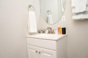 a white bathroom with a sink and a mirror at Serene Studio Retreat in Jacksonville +23 photos
