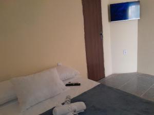 a bedroom with a bed with a remote control on it at Rancho JL in Marau