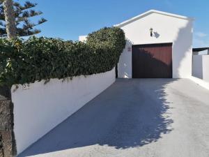 a driveway leading to a garage with a fence at Casa Paraiso in San Bartolomé