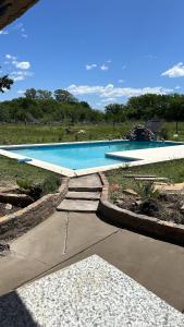a swimming pool with steps in front of it at Cabaña los Robles in Gowland