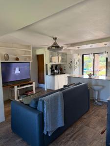 a living room with a blue couch and a kitchen at Cabaña los Robles in Gowland