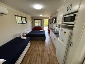 a small room with two beds and a kitchen at River Gum Tourist Park in Saint George