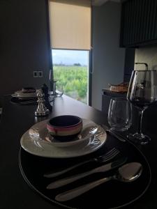 a table with a plate and fork and knife on it at ENTREVID suites & spa in Anchoris