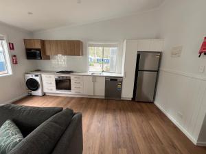 Una sala de estar con un sofá y una cocina. en Tasman Holiday Parks - Kioloa Beach, en Kioloa