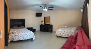 a bedroom with two beds and a ceiling fan at Hotel Prado´s in San Carlos