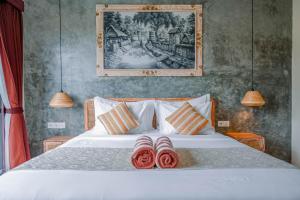 Un dormitorio con una cama con dos pantuflas encima. en Kidupa Villa 2 BR private pool, en Ubud 41 fotos más